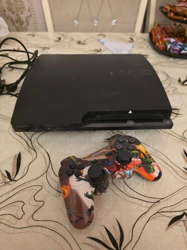 PS2 & PS1 (Sony PlayStation 2 & 1): Sony PlayStation 3 oyun konsolu. Qara rəngdə olan bu konsol yığcam və