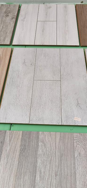 Laminat döşəmə panelləri – ağac teksturalı, açıq-boz və neytral