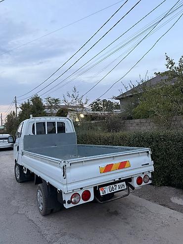she: Бортовой грузовик Kia Bongo III, белого цвета, в компактном формате — 1