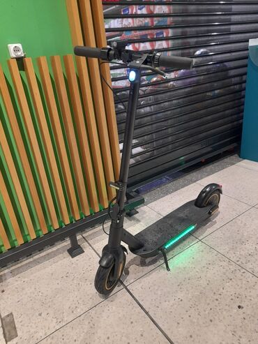 Samokatlar: Qara rəngli, yığcam dizaynlı elektrik skuter. İdarə etmək üçün