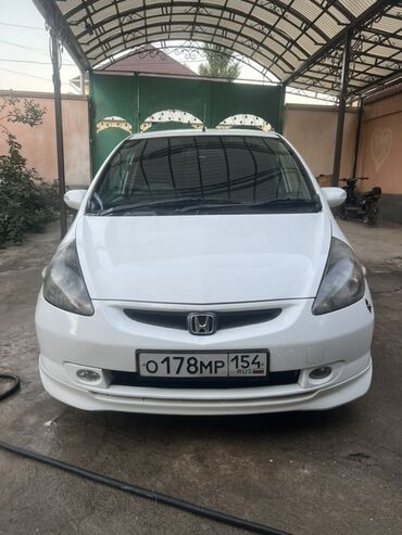 авто аренда по следующим выкуп: Белый хэтчбек Honda Fit с пятидверным кузовом, идеально подходящий для