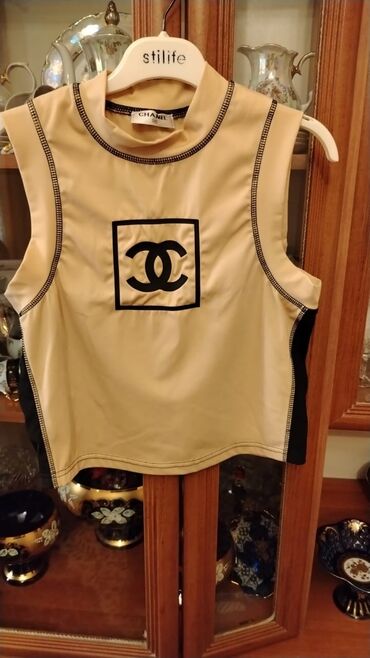 stringer alt paltarı: Rəng: bej (qara detallarla) Model: qolsuz, qısa top Brend üslubu: ön