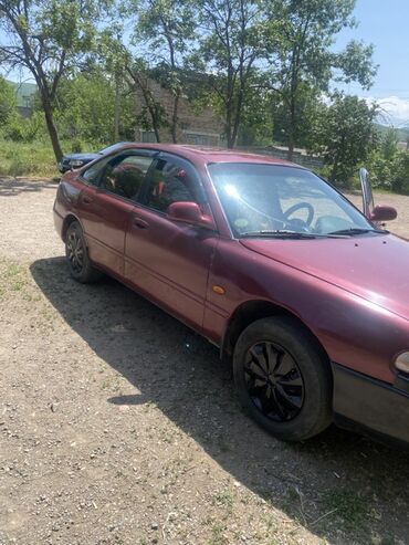диск gx: Автомобиль Mazda 626 в цвете "бордовый металлик", представленный в