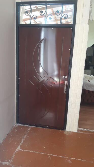 Сушилки: Üst hissəsində oyma dəmirdən bəzəkli transom pəncərəsi olan bu giriş