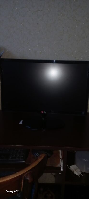 soyuducu maşın: Masanın üzərində yerləşən, LG brendinə məxsus qara rəngli monitor. Bu