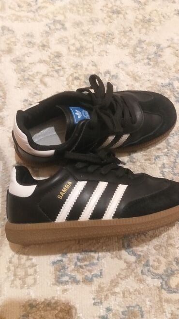 обувь адидас: Черные кроссовки Adidas Samba с белыми полосками, характерными для