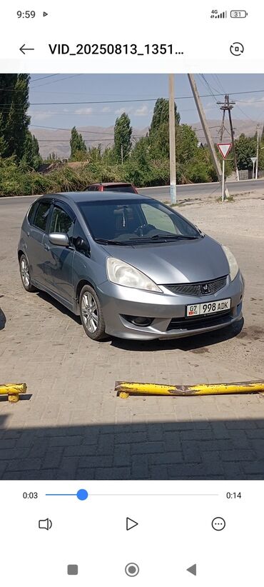 маленькая машина: Автомобиль Honda Fit серого цвета, четырехдверный хэтчбек. У