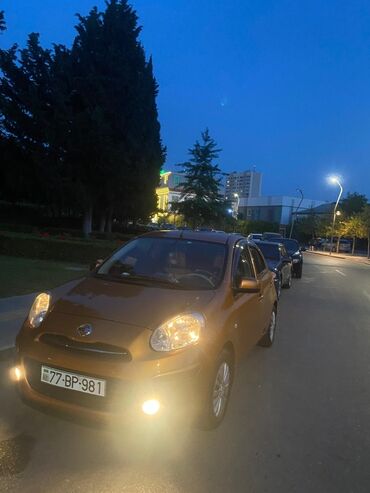 nissan micra qiymeti: Qızılı rəngdə olan Nissan Micra avtomobili. Bu model şəhər içi sürüş