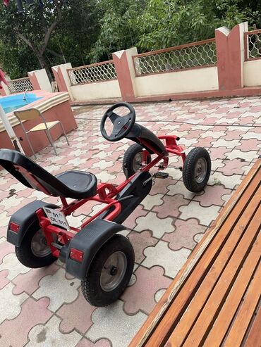 Manejlər: Dörd təkərli, pedallı qırmızı qart. Uşaqlar üçün pedallı hərəkət