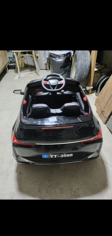 putdu maşın: Qara rəngdə, uşaqlar üçün nəzərdə tutulmuş elektrik avtomobil. İki