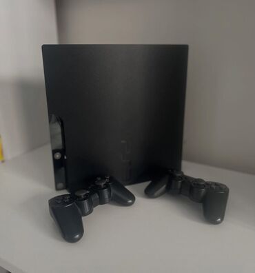 PS3 (Sony PlayStation 3): Qara rəngdə PlayStation 3 oyun konsolu. İki ədəd qara rəngdə olan
