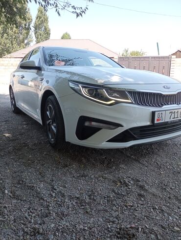 спрей скорая помощь: Белый седан Kia Optima с динамичным дизайном кузова. Оснащен