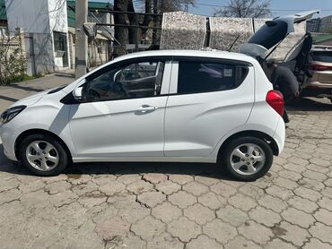 мини электромобиль: Белый хэтчбек Chevrolet Spark, предлагающий компактные размеры и