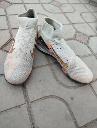 футбольный бутс: Пара футбольных бутс Nike, выполненных в светло-бежевом цвете с