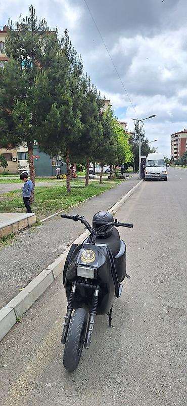 skuter toba: Qara rəngli şəhər skuteridir. Kompakt kuzov, enli ön təkər və ikili ön — 2