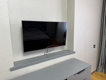 kreditle qril aparati: Divarda quraşdırılmış düz ekranlı televizor. Minimalist dizaynı