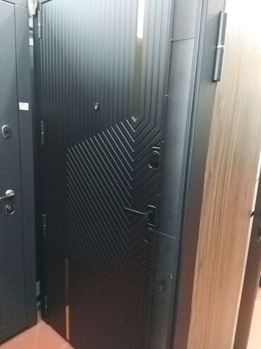 qapi ucun vinil: Qara rəngdə, müasir dizaynlı giriş qapısı. Qapının üzərində xüsusi