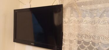 Smart TV bokslar: Divara quraşdırılmış qara rəngli yastı ekranlı televizor. Bu televizor