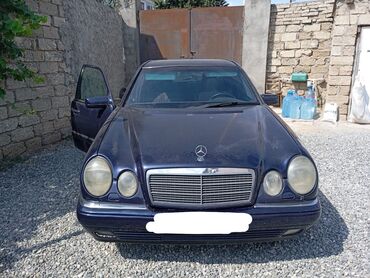 Avtomobil satışı: Tünd göy rəngdə Mercedes-Benz E-Class sedan avtomobili. Avtomobilin