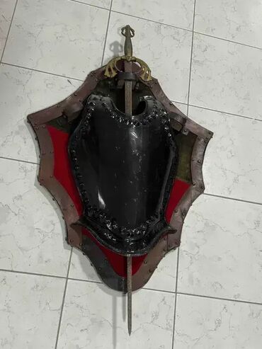 police za zid sa skrivenim nosačima: Štit i mač 103 x 65 cm (zidni ukras) Dobro stanje. Lično preuzimanje