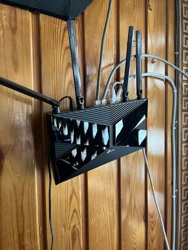 Kompüter və noutbuk aksesuarları: TP-Link brendinə məxsus qara rəngli simsiz router. Cihazın yuxarı