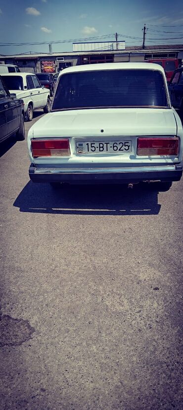 диски на жигули: Ağ rəngli sedan tipli avtomobil, geniş baqaj hissəsi və kapot altında
