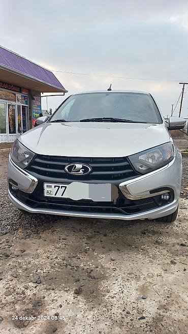 maşın şüşəsi: LADA Granta sedan, gümüşü rəngdə avtomobil. 4 qapılı kuzova malikdir — 4