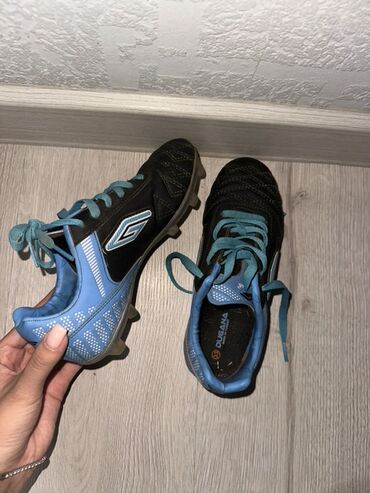 закрытое футбольное поле: Футбольные бутсы Umbro черного цвета с голубыми вставками и шнурками