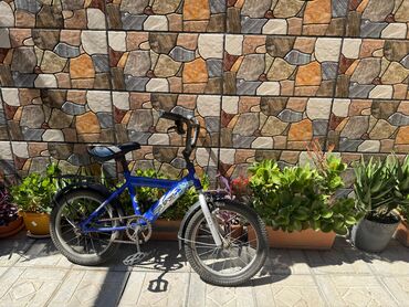 Mavi rəngli uşaq velosipedi, təkərlər üzərində qanadları, oturacaq