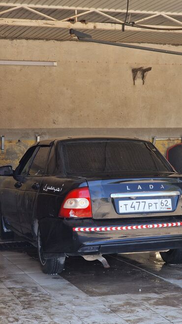 домкраты на авто: Черный седан Lada с белыми надписями на боковых дверях и