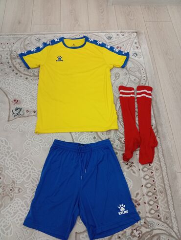 келме спартивка: Футбольная форма Kelme, состоящая из желтой футболки, синих шорт и