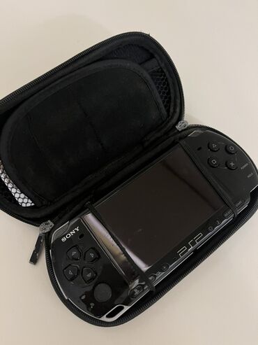 PSP (Sony PlayStation Portable): Sony PSP (PlayStation Portable) oyun konsolu, qara rəngdə, daşıma