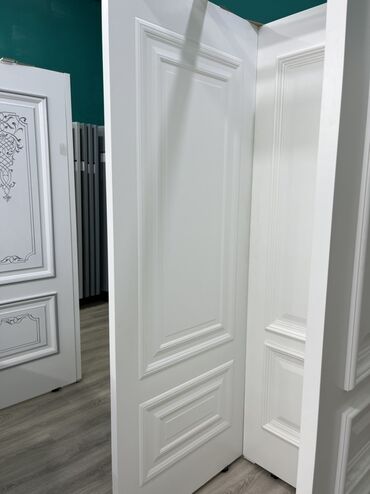 ikinci el qapi: Ağ rəngli, klassik dizaynlı qapı. Qapının üzərində dekorativ panellər