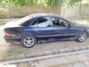 авто азербайджан: Tünd göy rəngli Opel Omega sedan modeli. Bu model dörd qapılı dizaynı