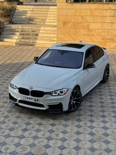 azsamand diski: Ağ rəngli, dördqapılı BMW sedan, idman üslublu ön bamperə və qara