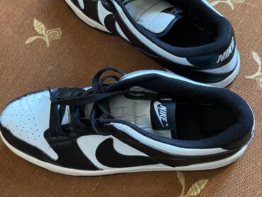 Botinkalar: Nike brendinə məxsus qara və ağ rəngli idman ayaqqabıları. Bu alçaq