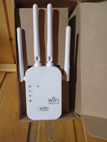 Modemlər və şəbəkə avadanlıqları: Ağ rəngdə, dörd antenalı Wi-Fi gücləndiricisi. Bu cihaz, Wi-Fi