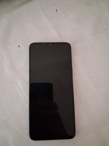 təlefon: Qara rəngli smartfon müasir dizaynı ilə seçilir. Cihazın yuxarı