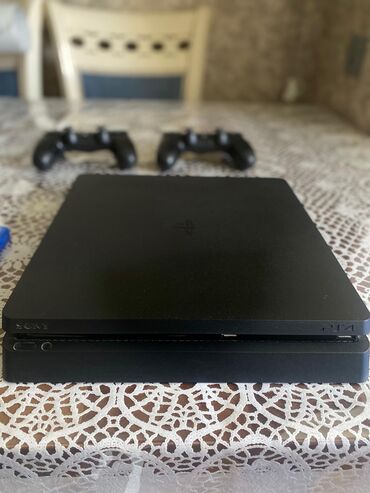 oyun konsolu ucuz: Qara rəngdə olan PlayStation 4 Slim oyun konsolu iki ədəd Dualshock 4