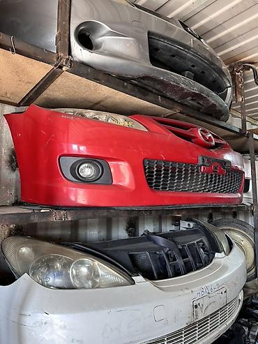 Передний бампер Mazda (с эмблемой), красный цвет. - Оригинальная