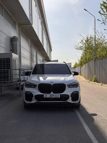 BMW: Автомобиль BMW X5 белого цвета с черными акцентами, такими как решетка