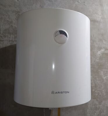 qapı və pəncərə: Ağ rəngli Ariston elektrikli su qızdırıcısı. Silindrik formaya