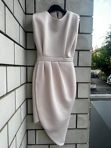 Elegantna koktel haljina u puder‑roze nijansi. Model bez rukava