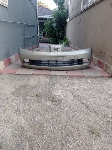 Ötürücü qutuların detalları: Nissan avtomobili üçün bej qızılı rəngli ön bamper. Bamperdə radiator