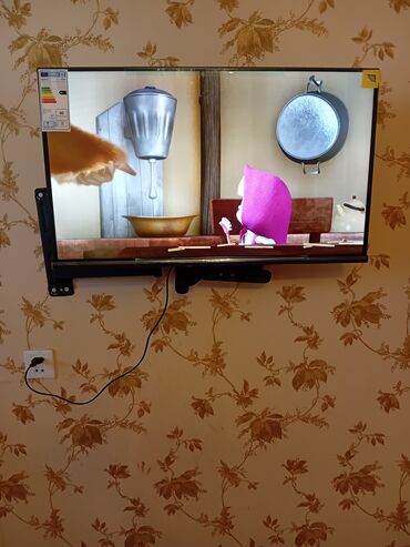 Televizorlar: Divarda quraşdırılmış, qara rəngli, nazik ekranlı televizor. Evdə və
