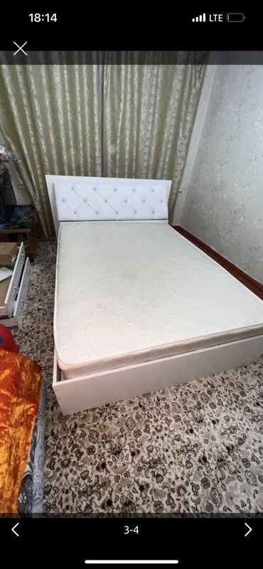 двуспальная кровать с подъемным механизмом: Белая кровать с мягким изголовьем, украшенным декоративными утяжками с