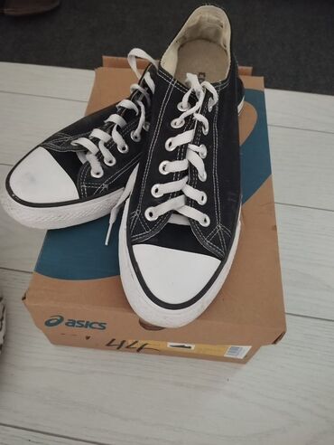 Кроссовки и спортивная обувь: Пара черных кед Converse с белой резиновой подошвой и мыском. Шнурки