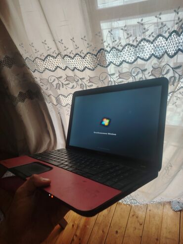 Masaüstü kompüterlər və iş stansiyaları: Toshiba markalı, qırmızı rəngdə noutbuk. Ekranında Windows əməliyyat