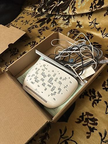 tp link modem satisi: TP-Link brendinə məxsus ağ rəngli simsiz router. Cihaz internet — 1