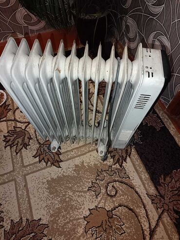 Ağ rəngdə, radiator tipli yağlı istilik cihazı. Evdə və ya ofisdə
